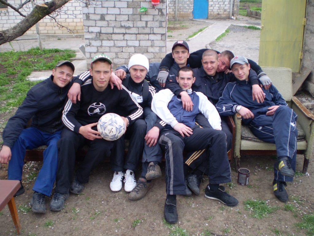 Учасники сидять колом на групі підтримки під плакатами Community Support та Recovery, заняття з реабілітації наркозалежних.
